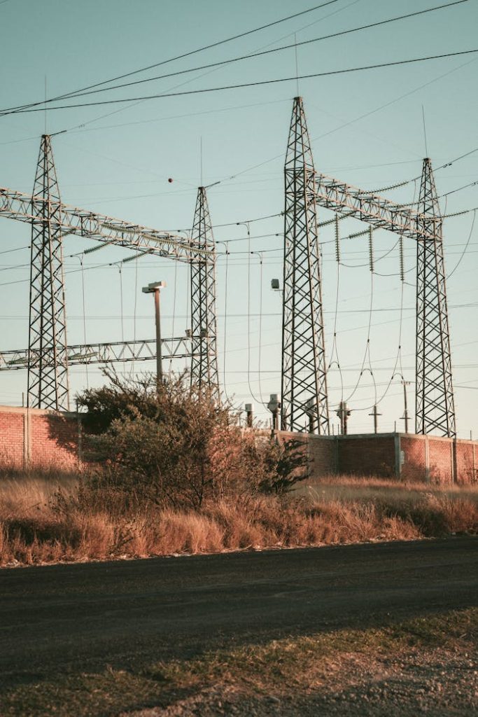 pexels-photo-33041841 Rustic open field showcasing a high voltage electrical substation during daytime.