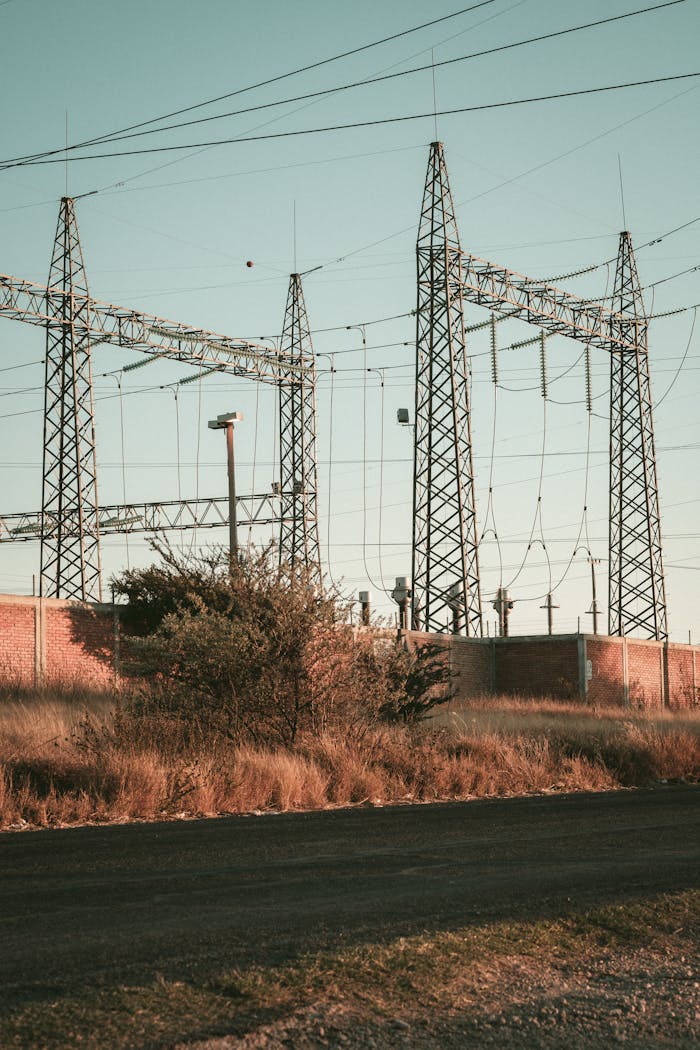services-04 Rustic open field showcasing a high voltage electrical substation during daytime.