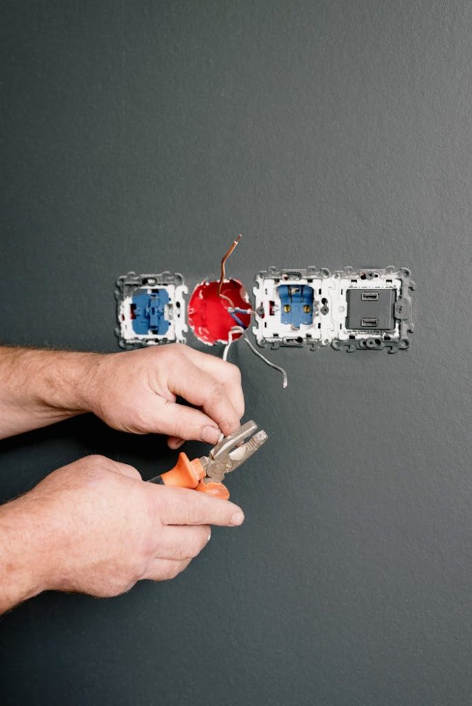 pexels-photo-5691590 Crop faceless electrician using pliers for installation sockets and switches in new apartment